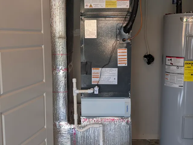 Newly installed air handler, Aprilaire filter cabinet and evaporator coil in a garage closet beside an AO Smith water heater, Clark County Indiana