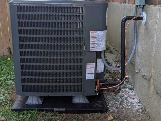 New condenser side angle showing the line-set routed to the wall disconnect