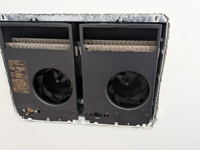 Existing Cadet electric fan heater with its grille removed before a mini split replacement