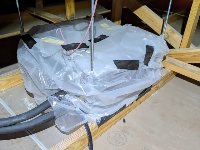 Ceiling cassette mini split indoor unit wrapped in plastic to protect it during finishing work