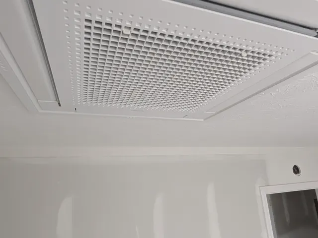 Finished ceiling cassette mini split indoor unit flush-mounted in a drywall ceiling