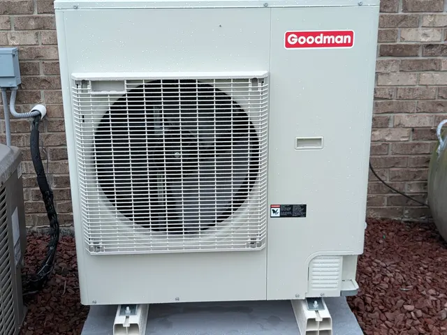 Goodman mini-split outdoor condenser installed on pad against brick wall Clark County Indiana