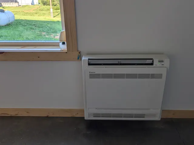 Daikin floor-console mini-split in a finished pole barn room with farmland through the window, Southern Indiana