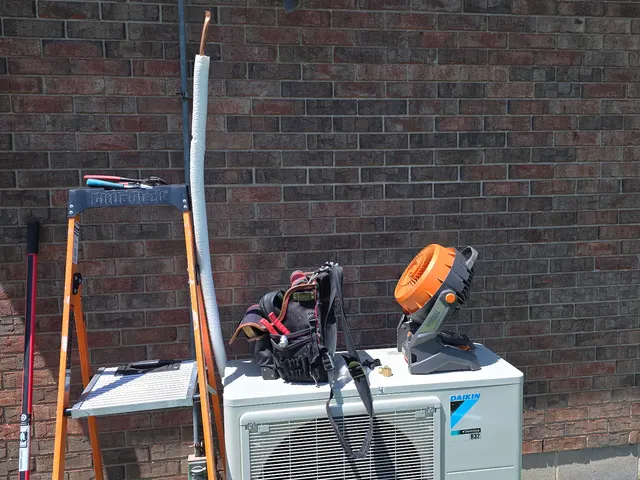 Daikin mini-split outdoor condenser unit on pad with ladder and tools at job site southern Indiana
