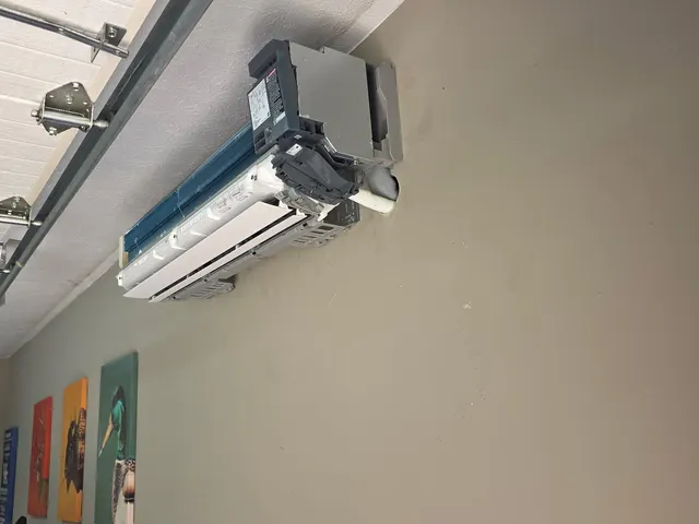 Mini-split indoor head unit with its front casing off during garage wall installation in southern Indiana