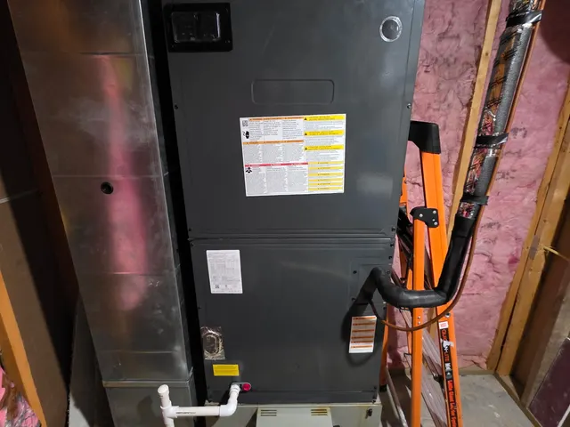 Air handler unit in unfinished basement with ladder and refrigerant line visible during inspection