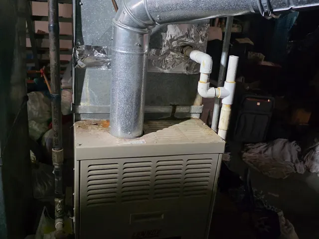 Lennox furnace ductwork and flue pipe in older basement during HVAC system assessment