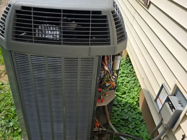 Trane central AC condenser with the electrical access panel removed, exposing the capacitor and control wiring during a second opinion inspection