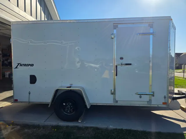 Henry Brothers HVAC white Intrepid enclosed work trailer parked at technician home base
