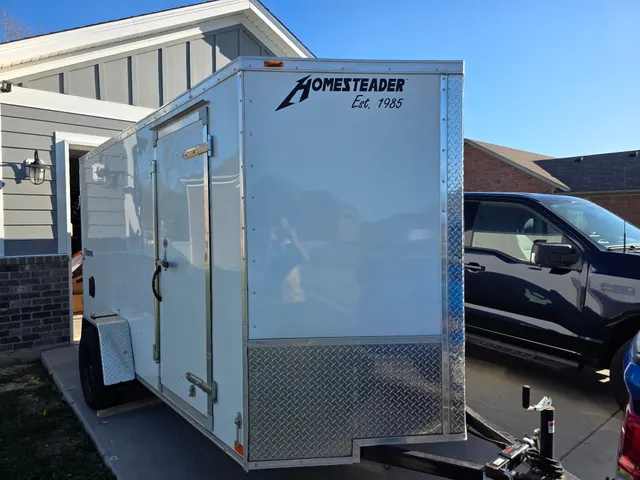 Henry Brothers HVAC Homesteader enclosed trailer parked with Ford truck at residential location